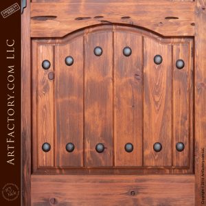vertical plank wood panel on door with decorative iron clavos