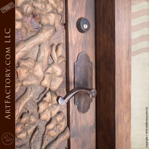 ornamental lever door pull on carved wood door