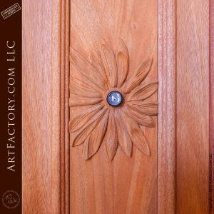 carved daisy flower on wood door with peephole